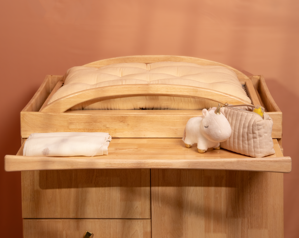 changing station on the cabinet with a pull out tray to place toiletries and extra stuff